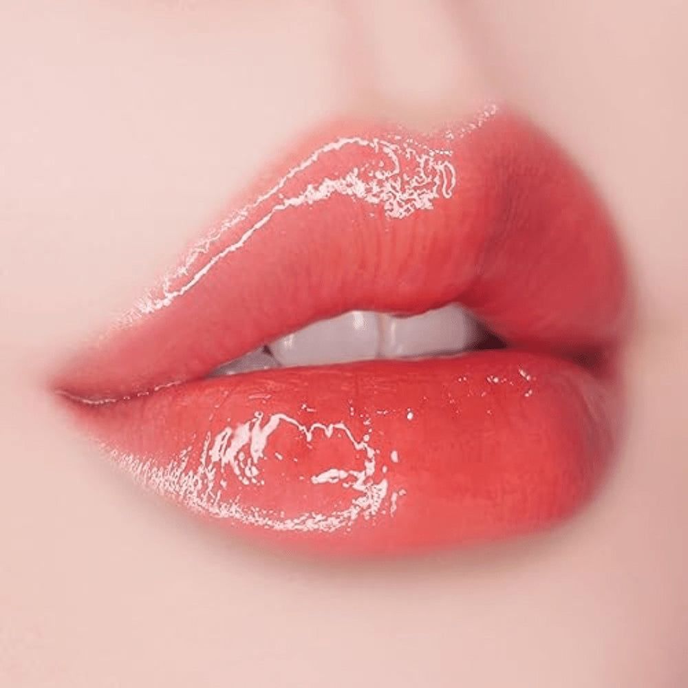 Nahaufnahme von Lippen, die mit glänzendem Lippen-Plumper bedeckt sind. Die Lippen sind rot und glänzend.