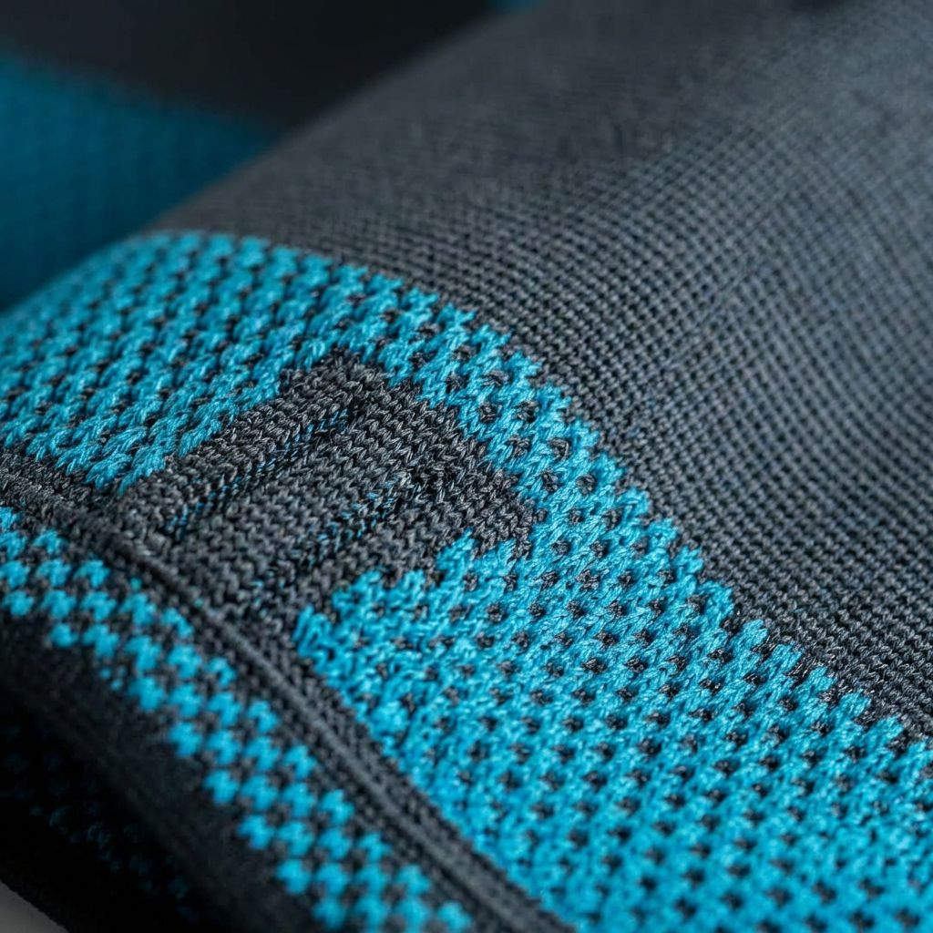 Nahaufnahme der Oberschenkelbandage. Blaues und schwarzes Textil. Quadratisches Muster. Detailansicht.