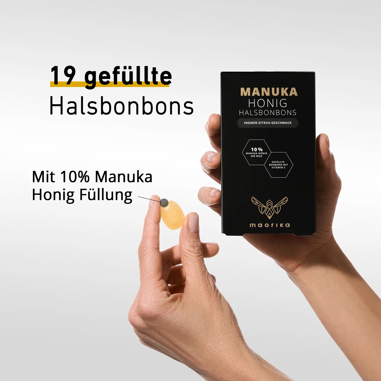 Hand hält eine Packung "MANUKA HONIG HALSBONBONS". Daneben ein Bonbon mit Füllung. Text: 19 gefüllte Halsbonbons.