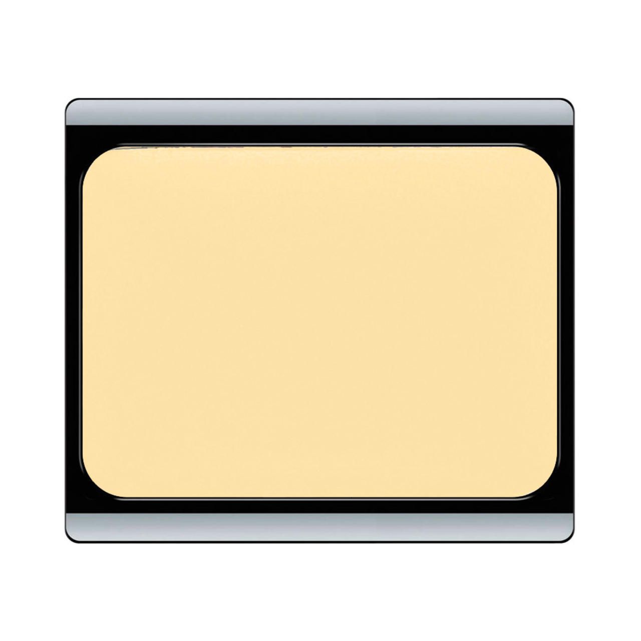 Kompakter, rechteckiger Korrektor. Hellgelbe Creme in schwarzem Gehäuse mit silbernem Rand. Abgerundete Ecken.