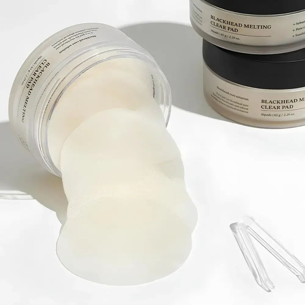 Geöffnete Dose mit Pads. Pads liegen heraus. Daneben eine Pinzette. Im Hintergrund weitere Dosen.