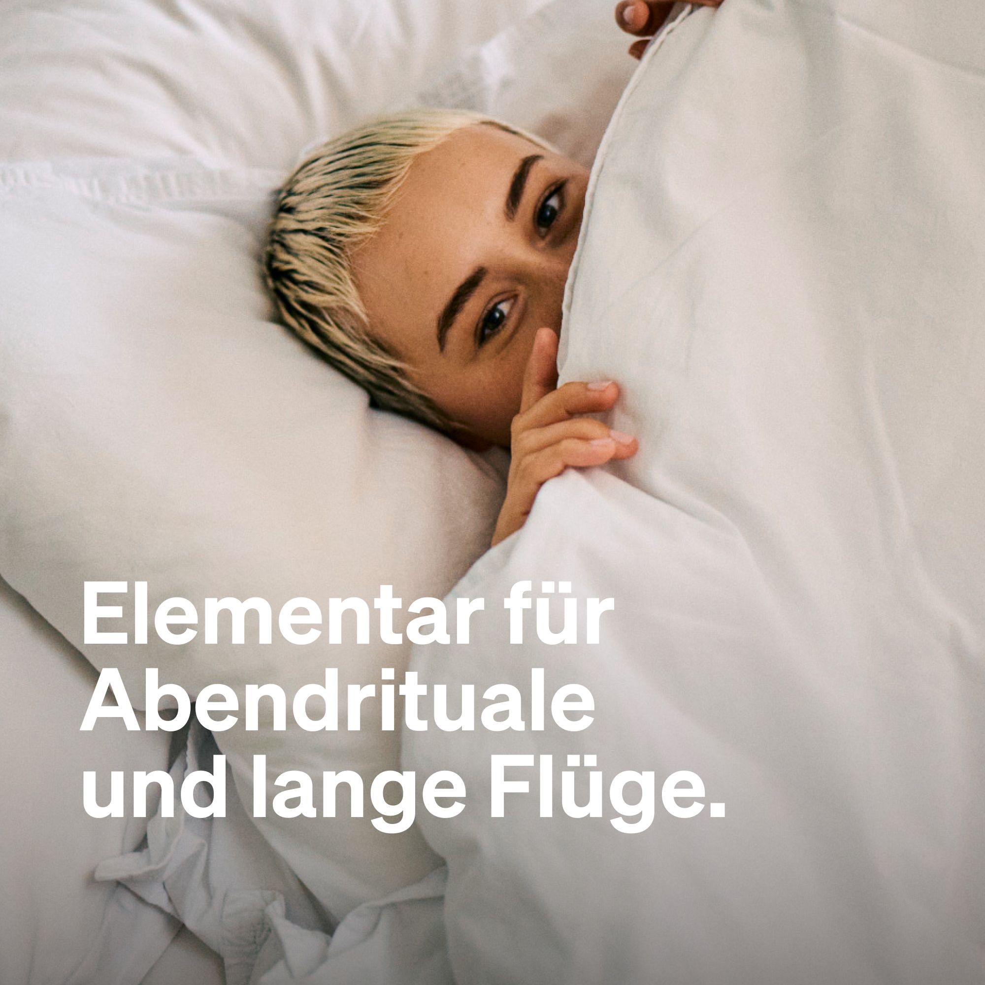 Person im Bett, bedeckt mit Bettwäsche. Text: Elementar für Abendrituale und lange Flüge.