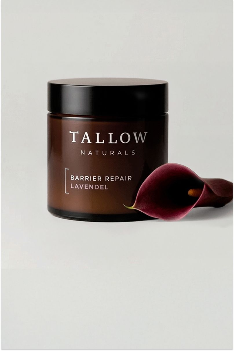 Braune Dose mit schwarzem Deckel. Aufschrift: Tallow Naturals, Barrier Repair Lavendel. Daneben eine dunkelrote Blume.