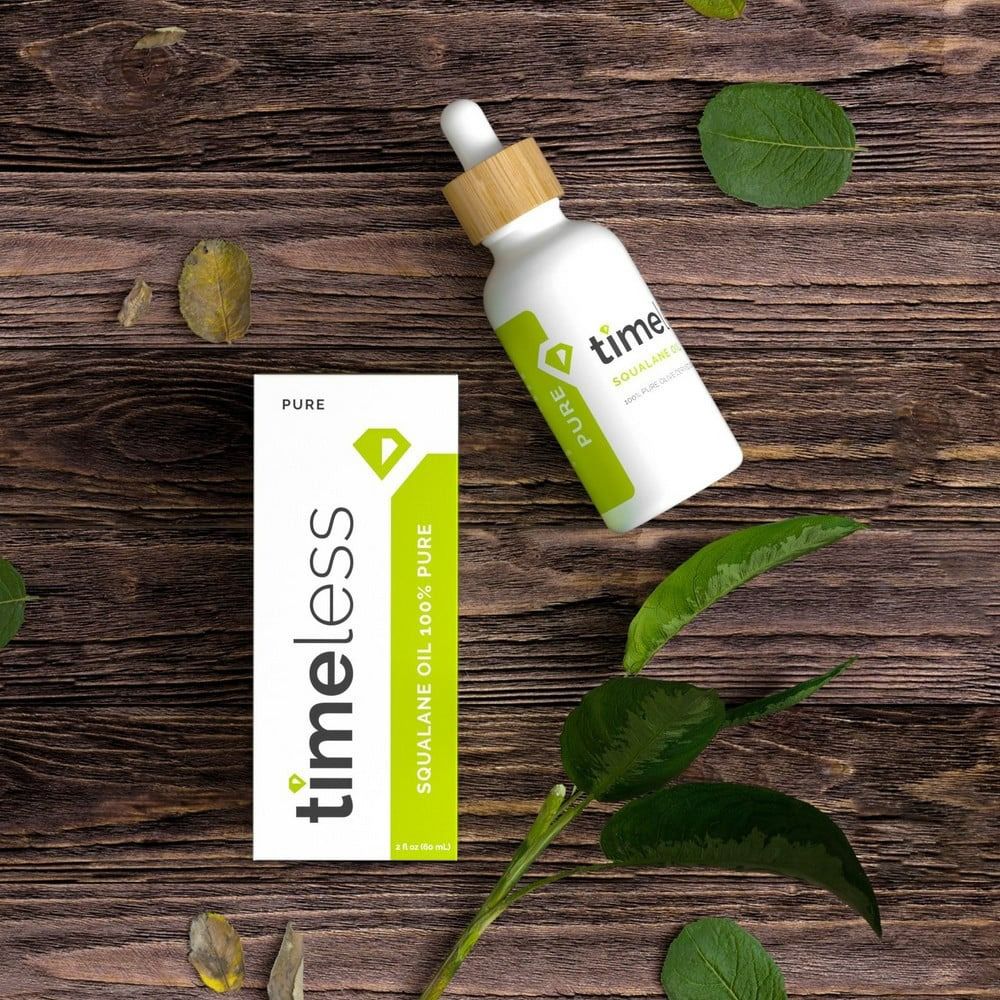 TIMELESS Squalane Oil Flasche und Schachtel auf Holz. Grüne Blätter. Aufschrift: Squalane Oil 100% Pure.
