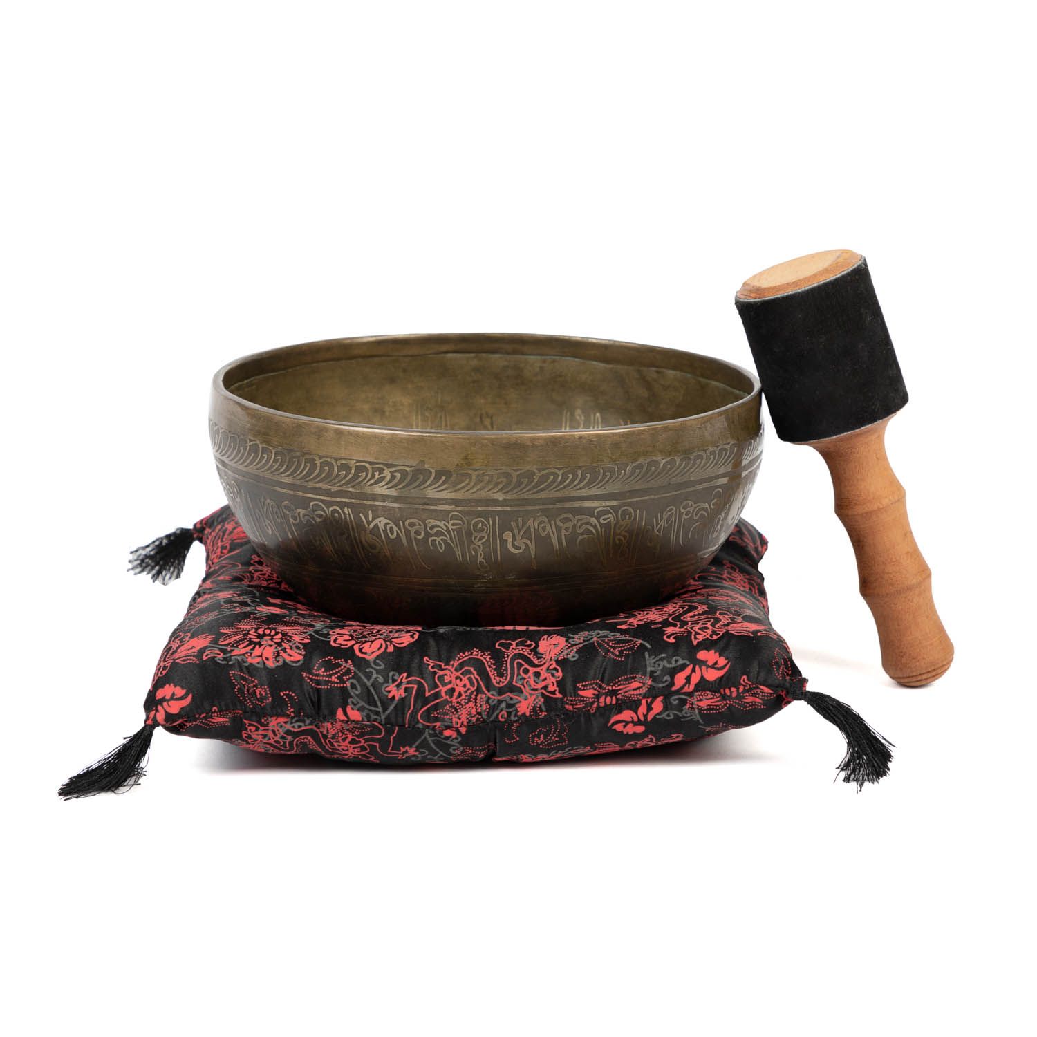Klangschale auf Kissen, mit Holzschlägel. Schale aus Metall, Kissen mit rotem Muster, Schlägel mit Holzgriff und schwarzem Kopf.