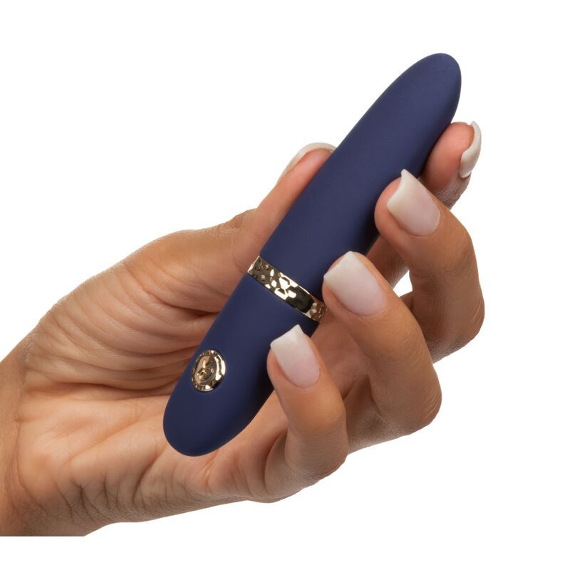 Hand hält ein dunkelblaues, kompaktes Vibrationsmassagegerät mit silbernem Ring und goldenem Knopf.