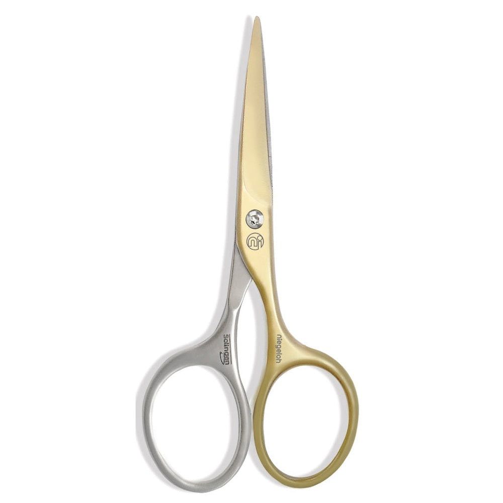 Schere mit goldfarbenen und silberfarbenen Griffen. Auf der Schere sind Logos und Schriftzüge zu sehen.