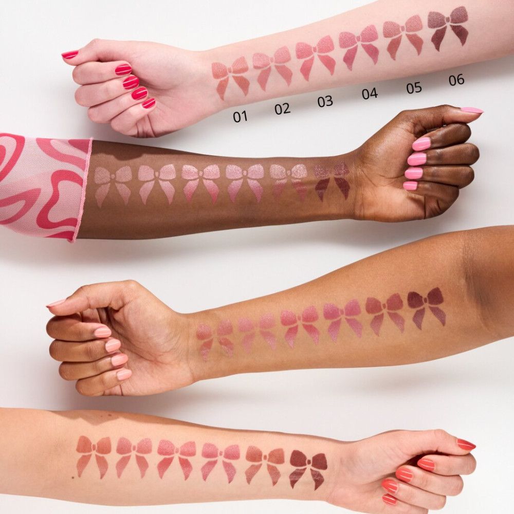 Arme mit Lippenstift-Swatches in verschiedenen Farbtönen. Auf jedem Arm sind Schleifen abgebildet. Verschiedene Hauttöne.