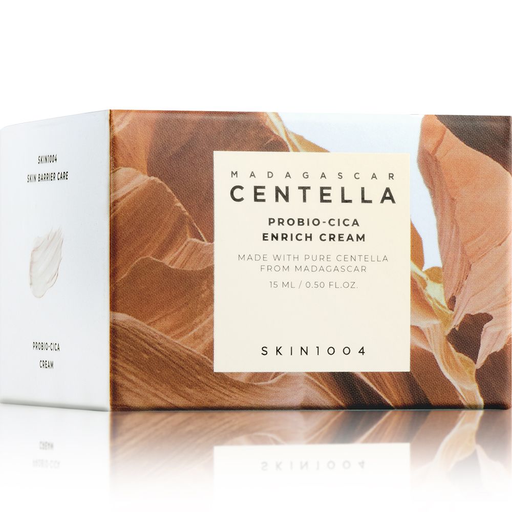 Kartonverpackung mit Produktnamen: MADAGASCAR CENTELLA PROBIO-CICA ENRICH CREAM. Marke: SKIN1004. Hintergrund: Landschaft.