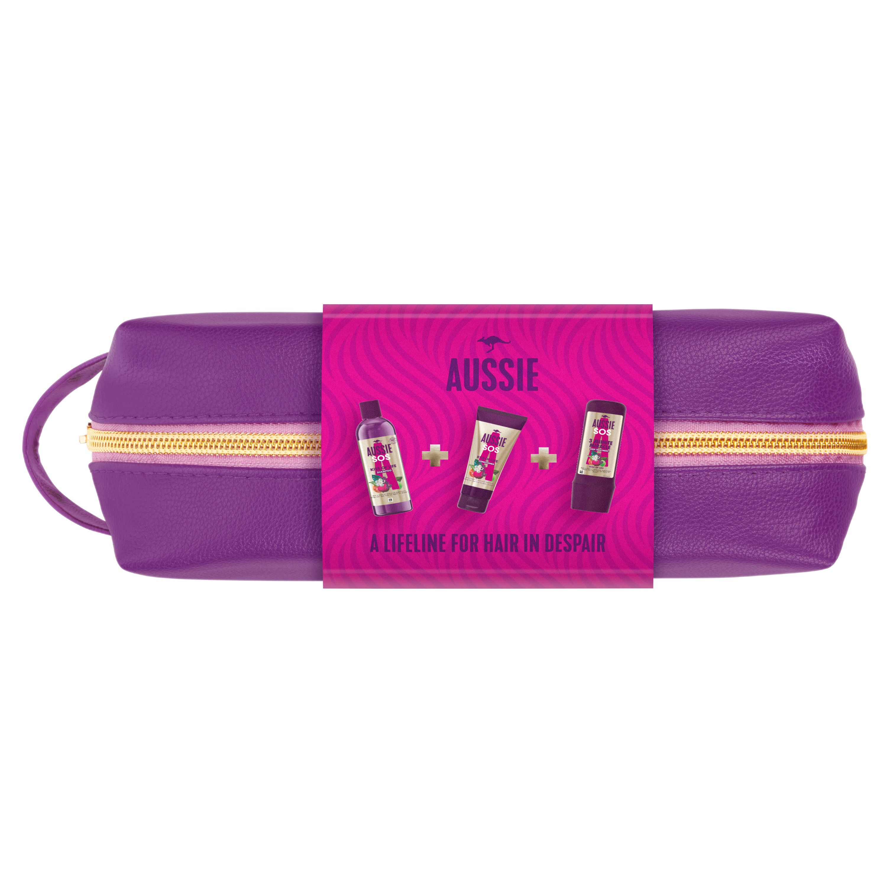 Lila Kosmetiktasche mit pinkfarbener Banderole. Aufdruck: AUSSIE. Abgebildet sind Shampoo, Conditioner und Haarmaske.
