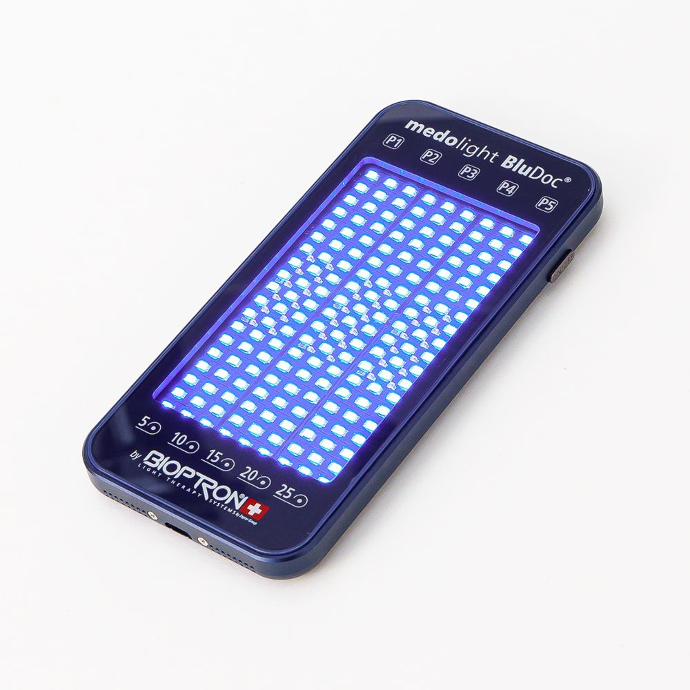 Blaues medolight BluDoc-Gerät mit leuchtenden LEDs. Zeigt Zeitangaben und das Bioptron-Logo. Rechteckige Form.