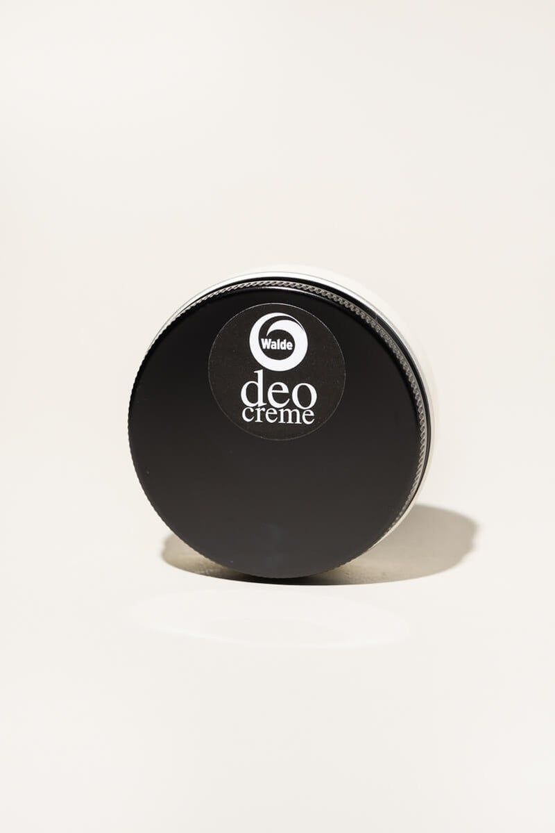 Runde Deocreme-Dose mit schwarzem Deckel. Auf dem Deckel befindet sich ein Aufkleber mit dem Logo und der Aufschrift "deo creme".