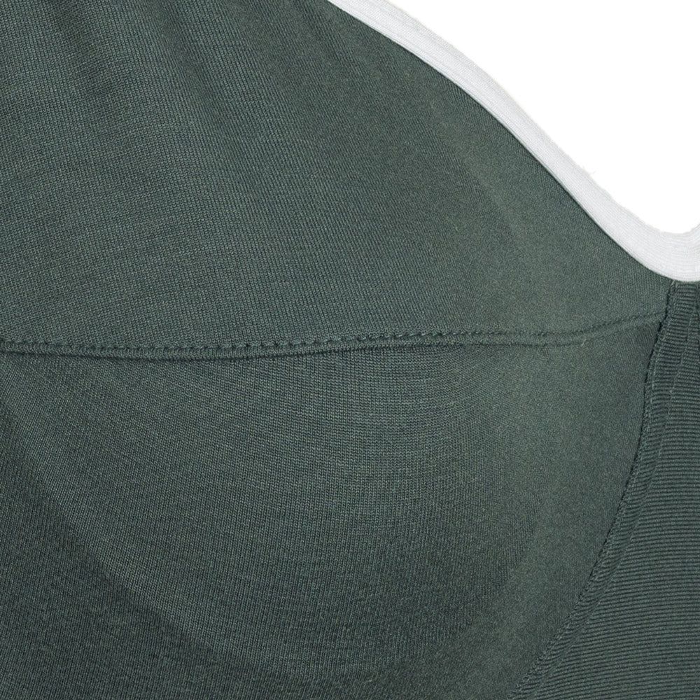 Detailaufnahme des grünen Still-BHs. Nahtdetails und Stoffstruktur sichtbar.