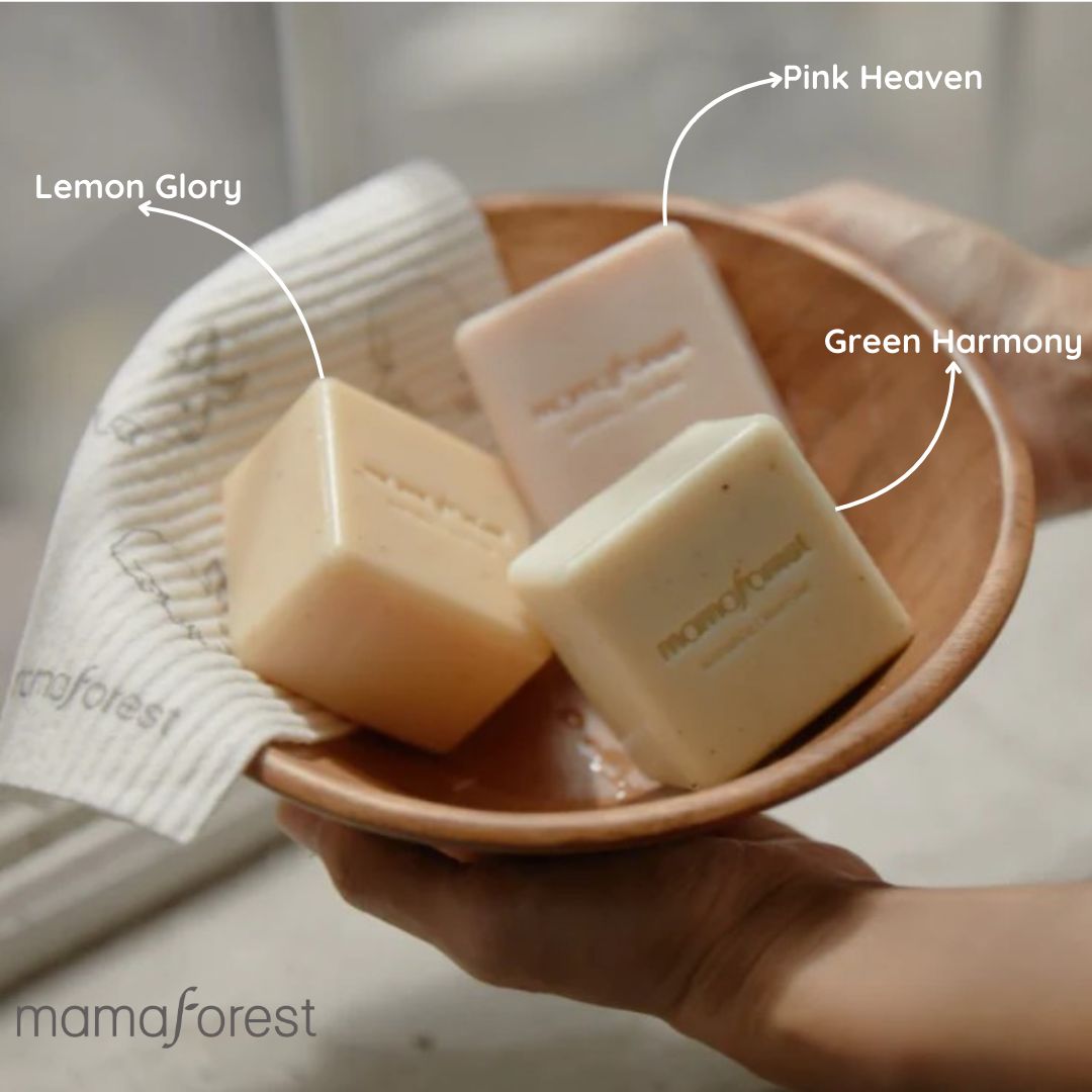 Drei Seifenstücke in einer Holzschale. Beschriftung: "Lemon Glory", "Pink Heaven", "Green Harmony" und "mamaforest".