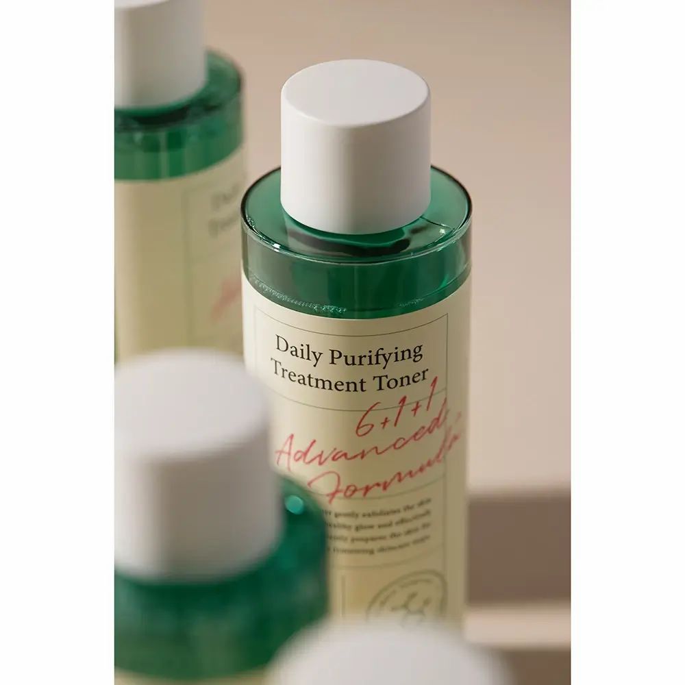 Mehrere Flaschen AXIS-Y Daily Purifying Treatment Toner. Weiße Deckel, grüne Flüssigkeit, weißes Etikett mit Text. Aufschrift: 6+1+1 Advanced Formula.