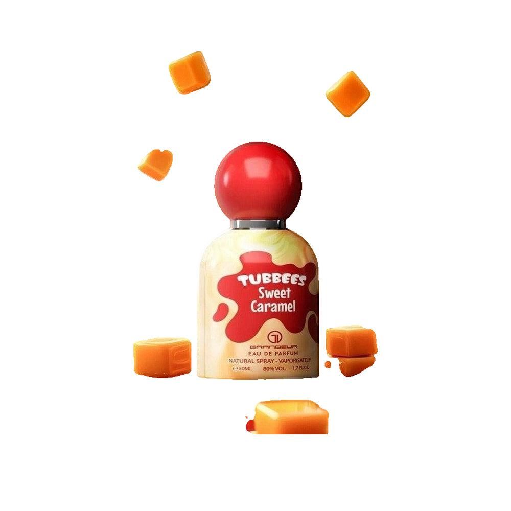 Parfumflasche mit rotem Deckel und Schriftzug. Aufschrift: TUBBEES Sweet Caramel. Umgeben von Karamellwürfeln.