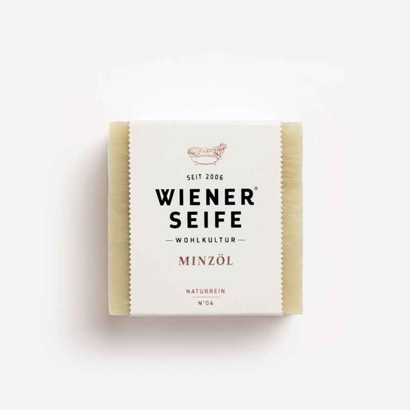 Seife mit Papierbanderole. Aufschrift: Wiener Seife, Minzöl, Naturrein N°04. Logo: Badewanne.