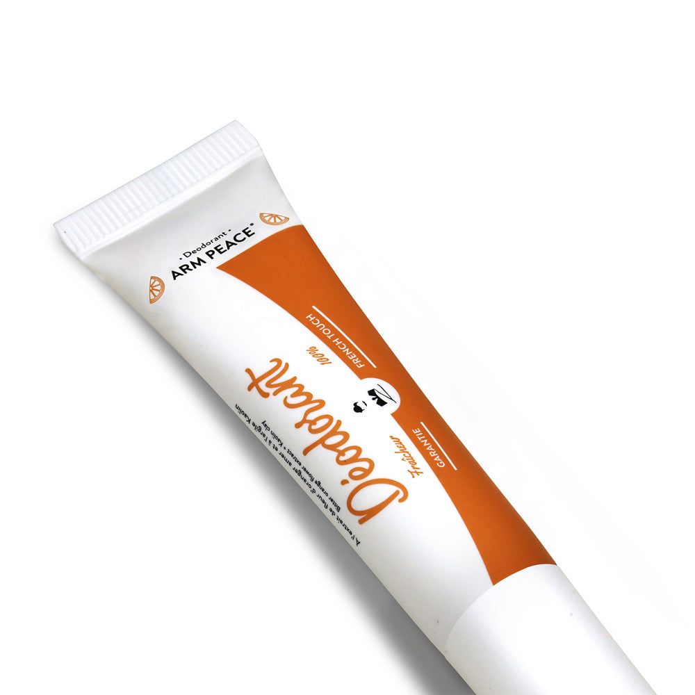 Deodorant-Tube, weiß mit orangefarbenem Design. Text: Deodorant, ARM PEACE, Peach Touch, Garantie.