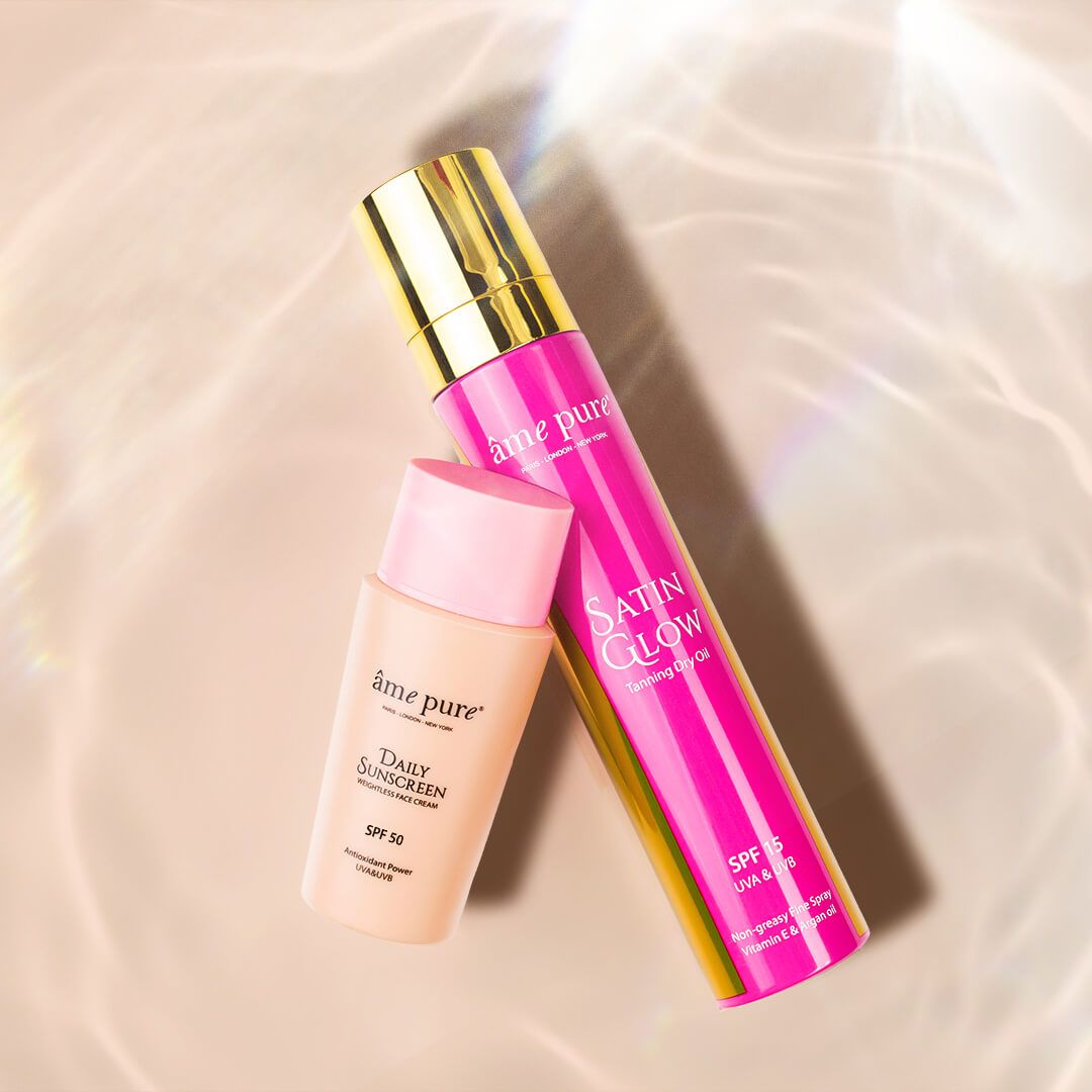 Sonnenschutz-Set mit Tages-Sonnenschutz SPF 50 und Satin Glow Bräunungsöl auf hellem Hintergrund.