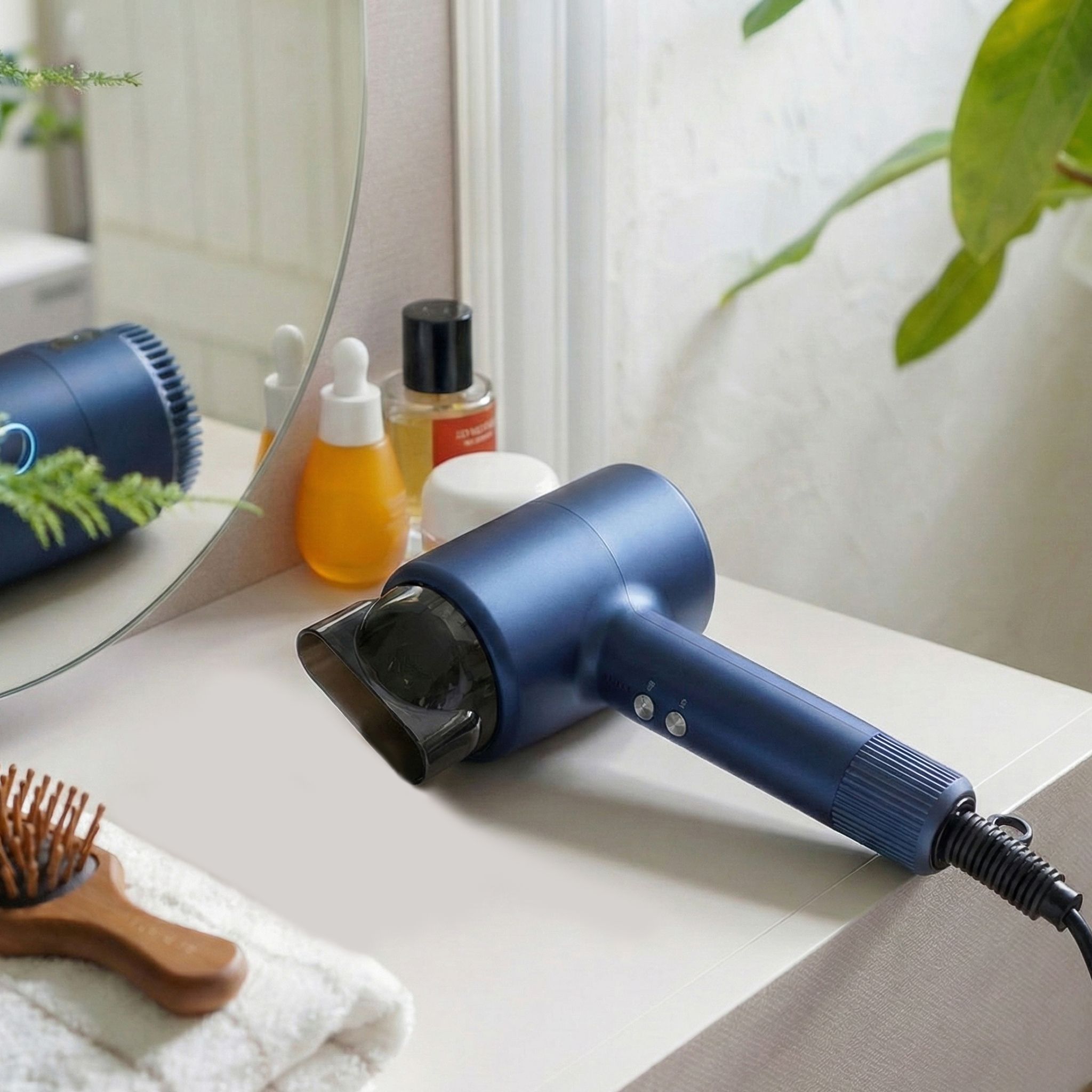 Blauer Haartrockner auf einer Ablage neben Kosmetikprodukten und einem Handtuch. Konzentratoraufsatz angebracht.