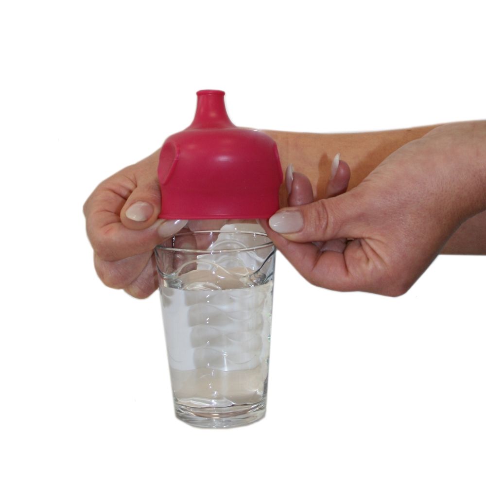 Roter Silikon-Deckel mit Schnabelaufsatz auf Glas. Hände halten Glas mit Eiswasser. Weißer Hintergrund.
