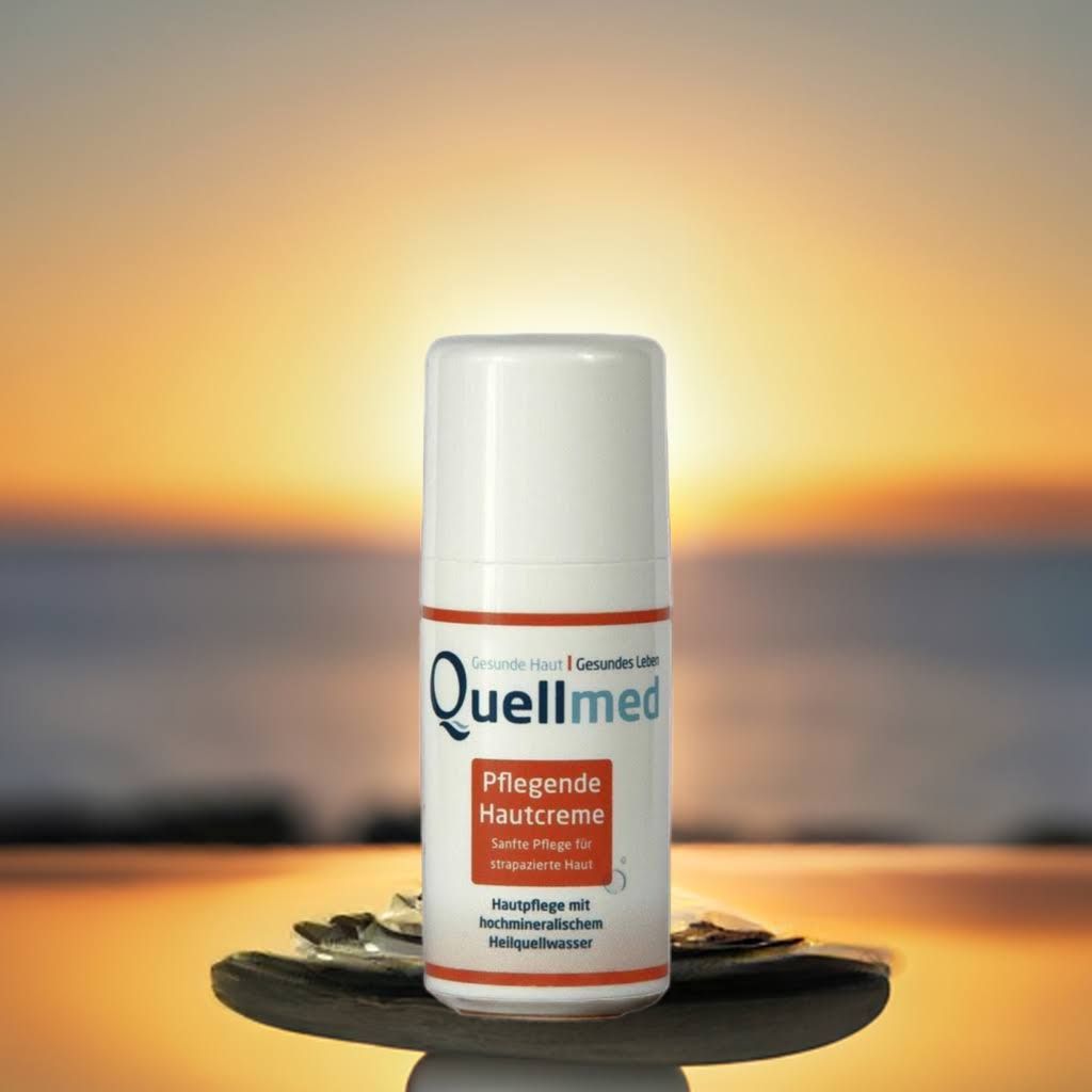 Produktflasche "Quellmed" auf einer Holzschale vor Sonnenuntergang. Produktname und Text sind sichtbar.