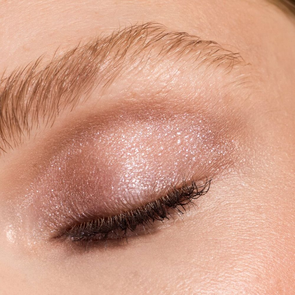 Nahaufnahme eines Auges mit rosa Lidschatten. Wimpern sind getuscht.