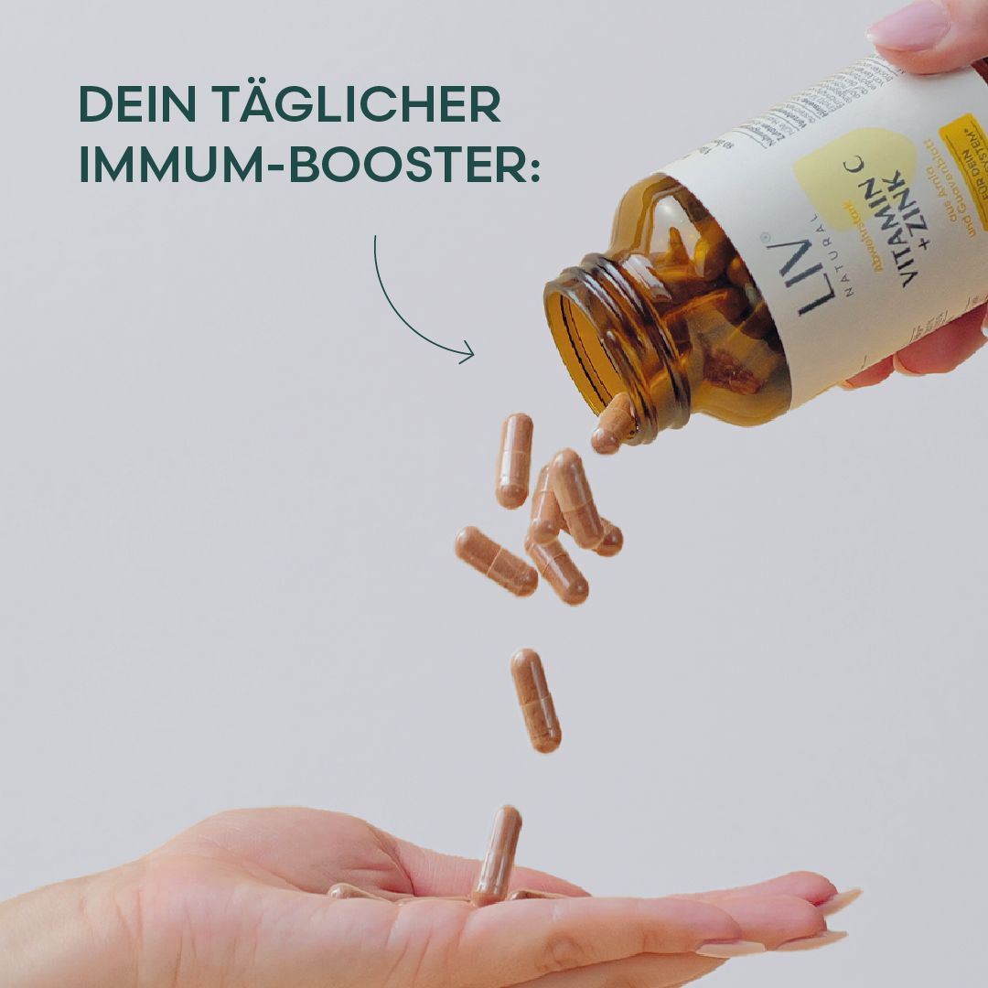 Hand gießt Kapseln aus einer Flasche. Flasche mit Etikett "LIV Vitamin C + Zink". Kapseln fallen in die Hand. Text: Dein täglicher Immum-Booster.