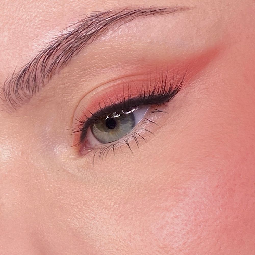 Nahaufnahme eines Auges mit Lidschatten und Wimperntusche. Hautton: hell. Augenbraue sichtbar.