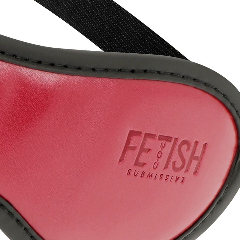 Nahaufnahme der roten Augenmaske mit schwarzem Rand. Aufschrift: FETISH SUBMISSIVE. Detailansicht des Produkts.