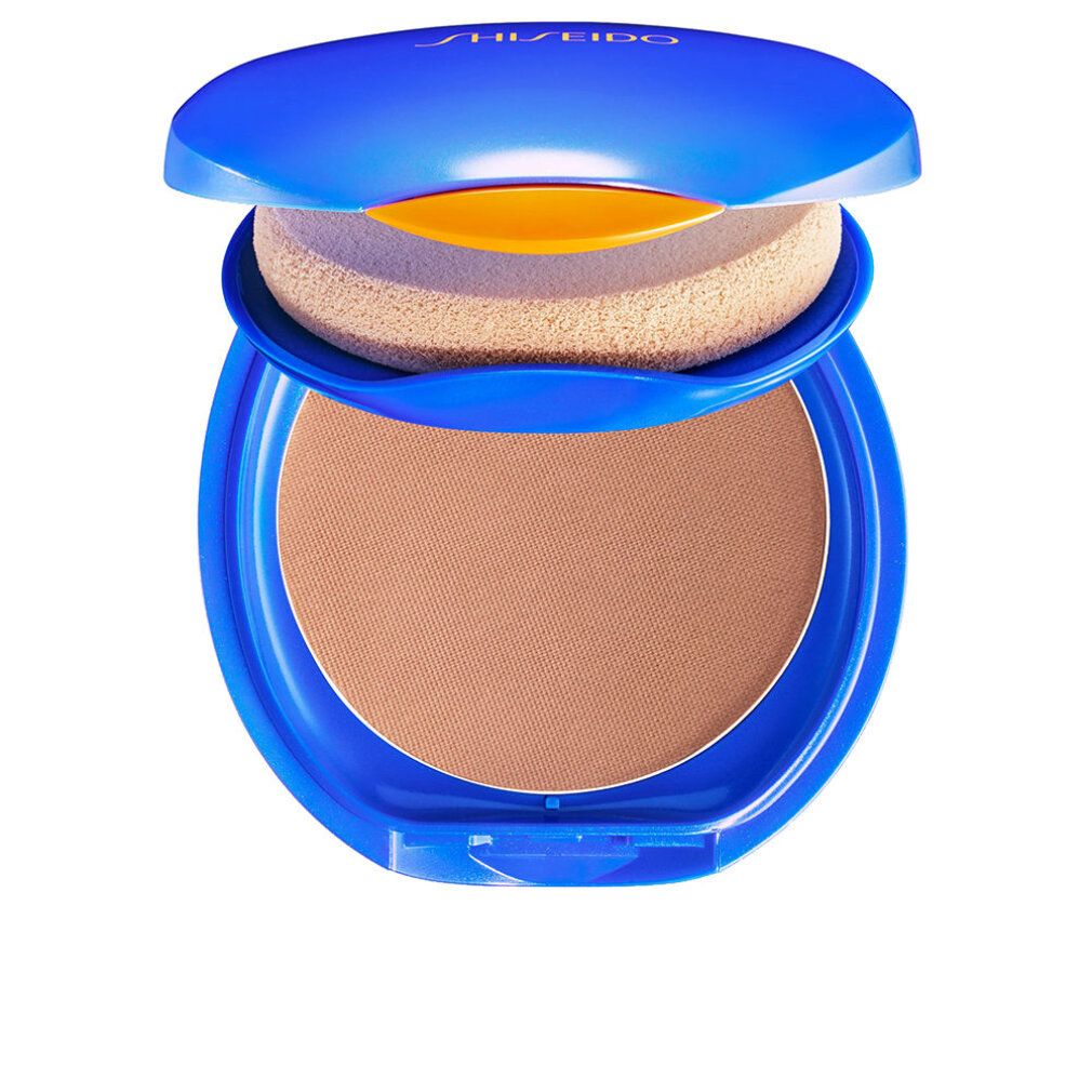Blauer Kompakt-Make-up-Behälter, geöffnet. Enthält Schwamm und braunen Puder. Oben steht "Shiseido".