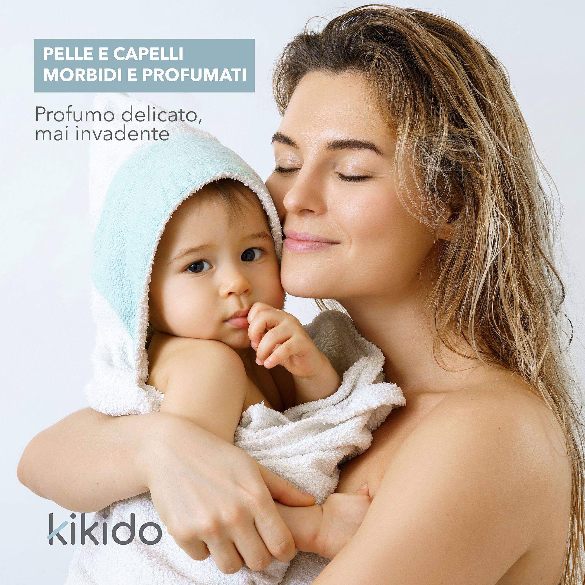 Mutter umarmt Baby in Handtuch. Text: Kikido, Pelli e capelli morbidi e profumati.