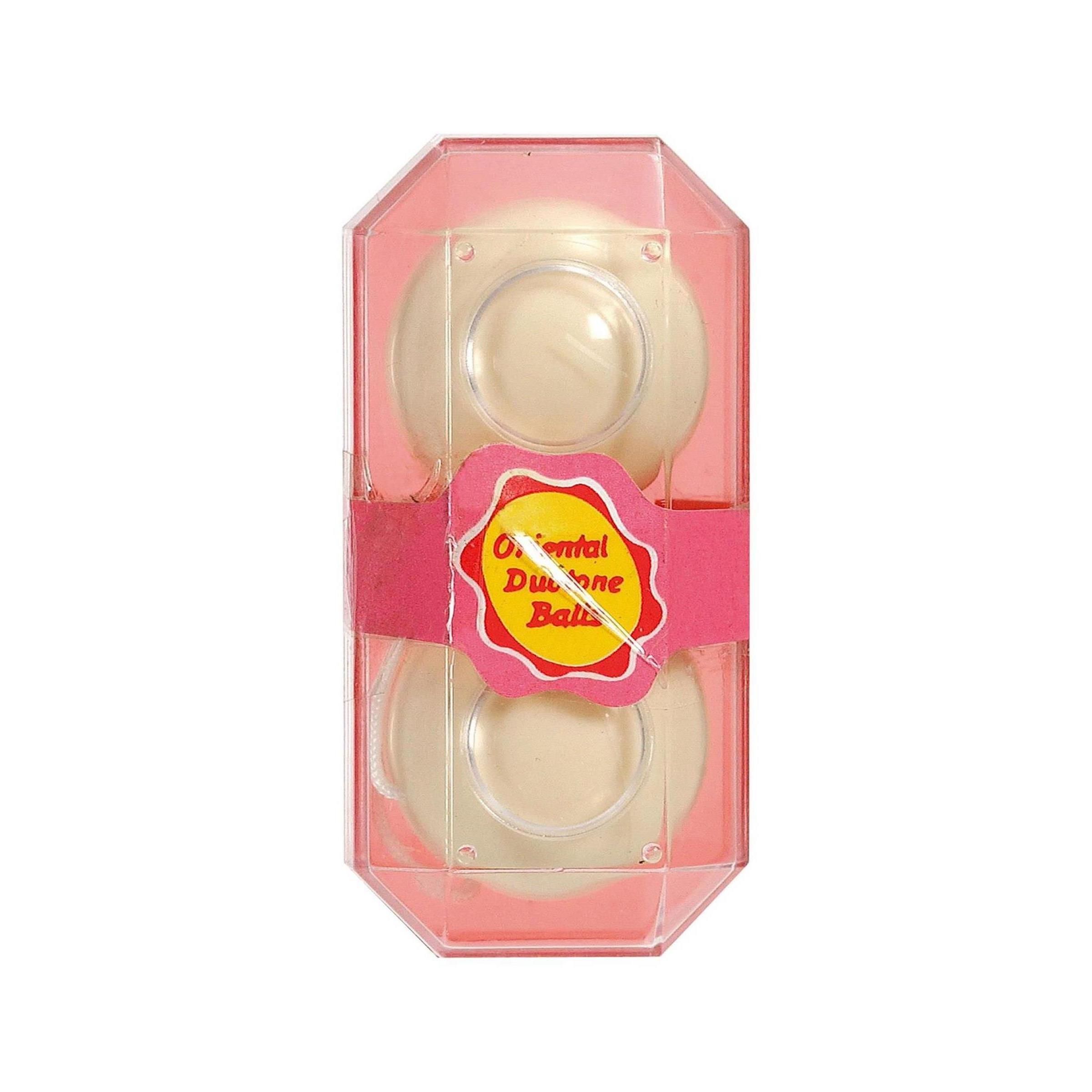 Zwei cremefarbene Kugeln in einer rosafarbenen, transparenten Verpackung. Ein rosafarbenes Band mit Text umhüllt die Kugeln. Aufschrift: "Oriental Duo Balls".