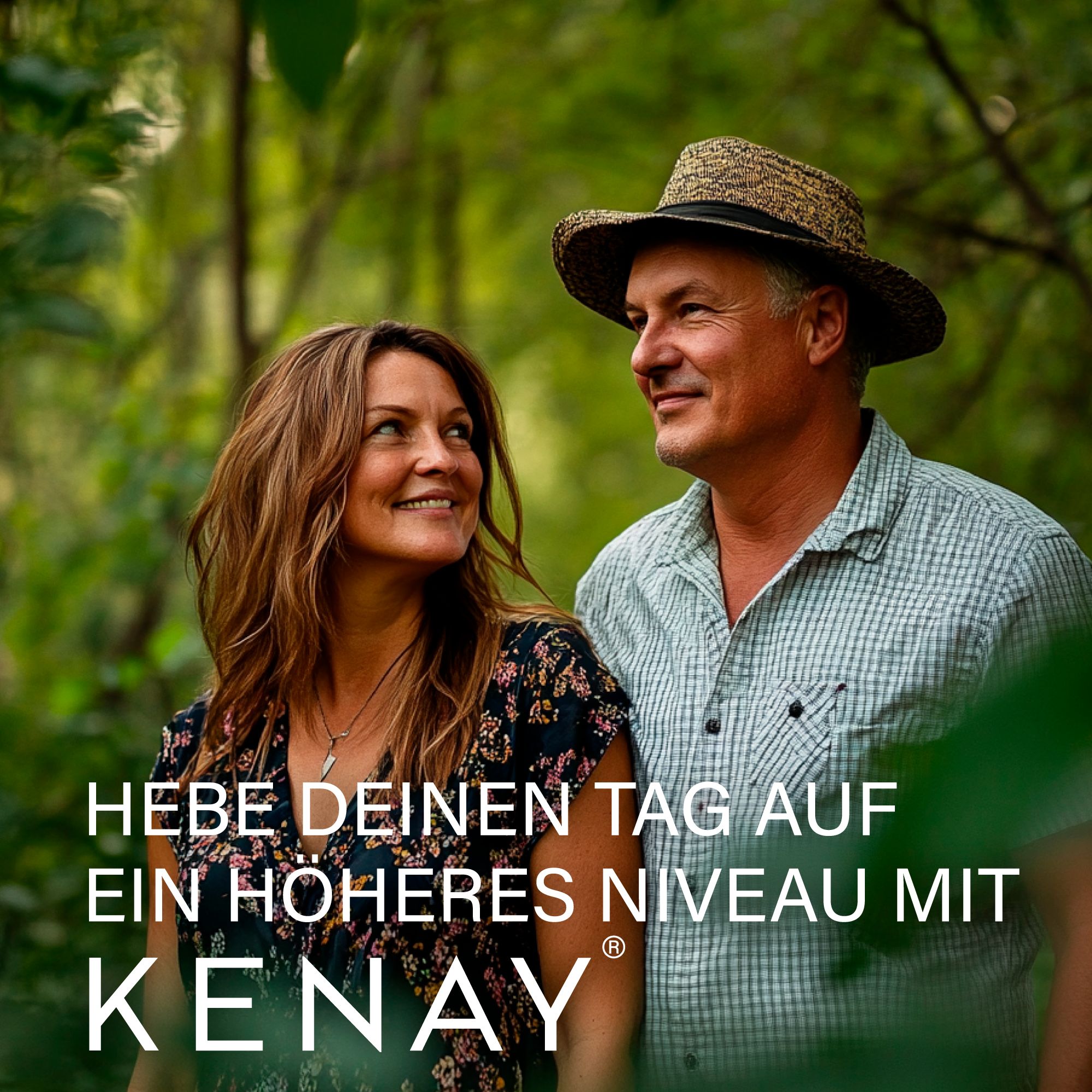 Ein Paar lächelt im Wald. Text: Hebe deinen Tag auf ein höheres Niveau mit KENAY®.