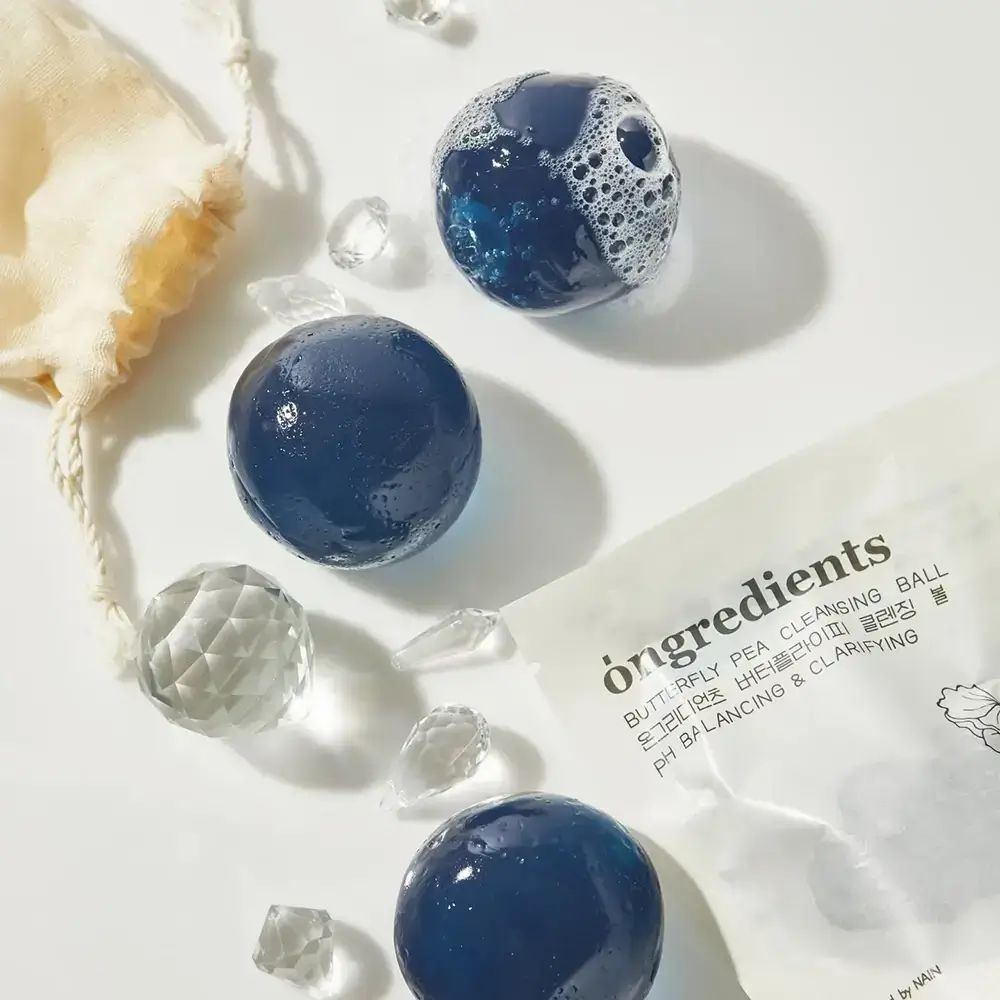 Blaue Bälle, einige mit Schaum. Beutel und Verpackung mit Text.