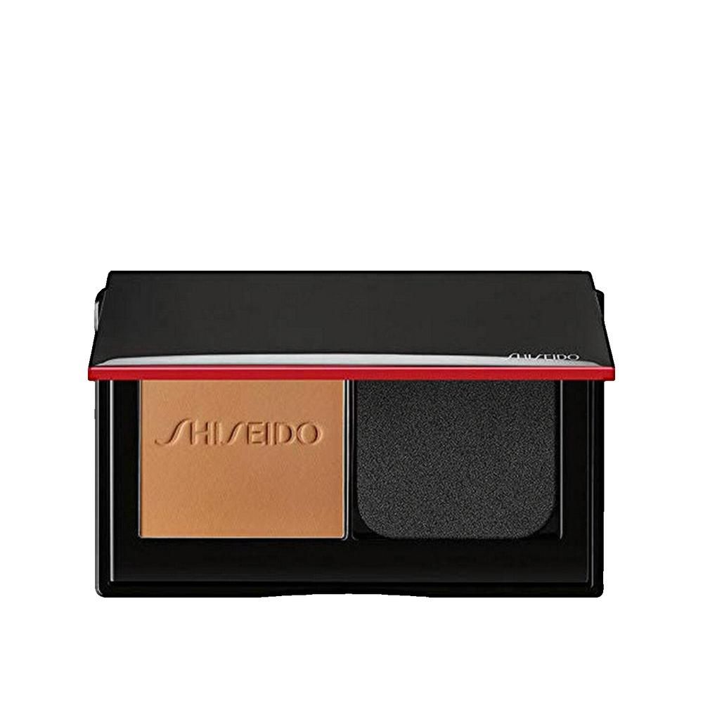 Kompakt-Make-up-Puder mit Schwamm. Schwarze Hülle mit rotem Akzent. Marke Shiseido sichtbar.