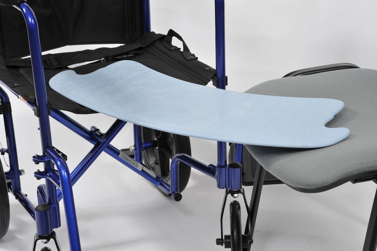 Transferbrett zwischen Rollstuhl und Stuhl. Blaues Brett, Rollstuhl links, Stuhl rechts.