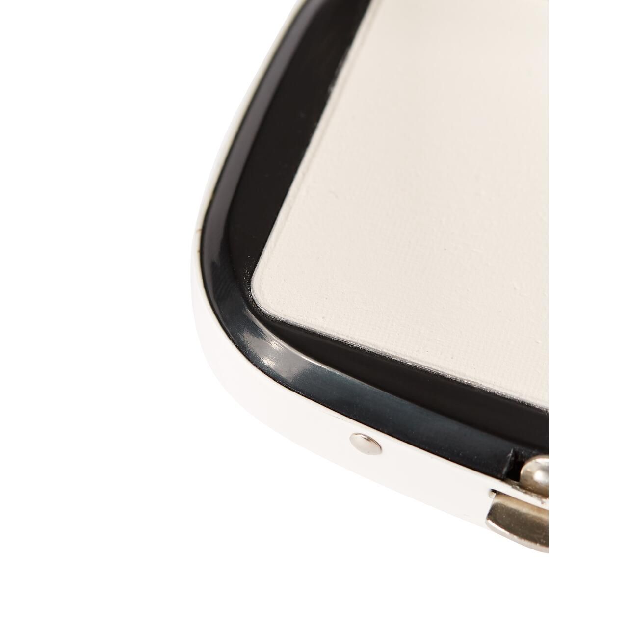 Weißer Kompaktpuder in einer weißen Dose mit schwarzem Rand. Der Deckel ist teilweise geöffnet.