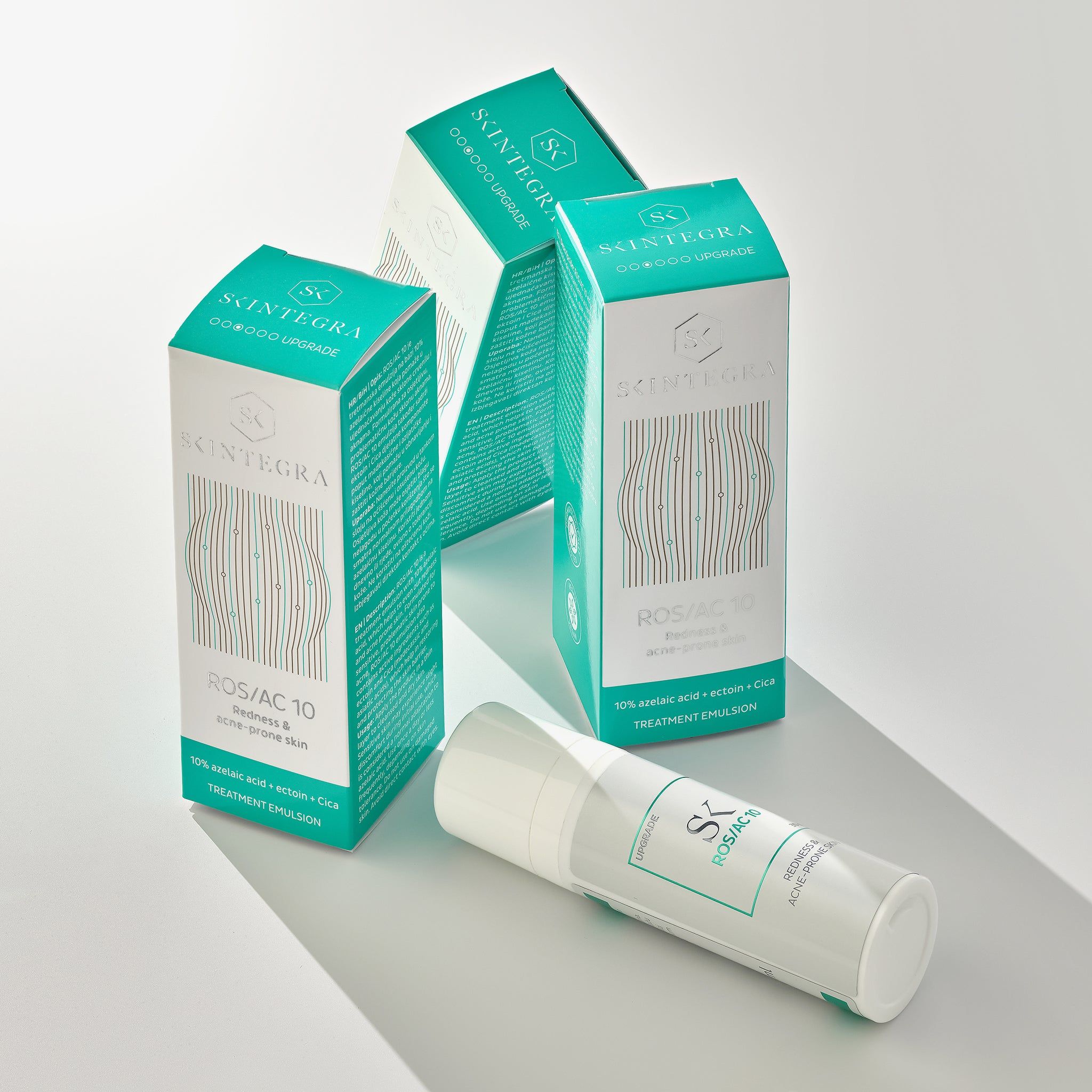 Drei Verpackungen und ein Flakon. Aufschrift: Skintegra, ROS/AC 10, Redness & acne-prone skin. Text: 10% azelaic acid.