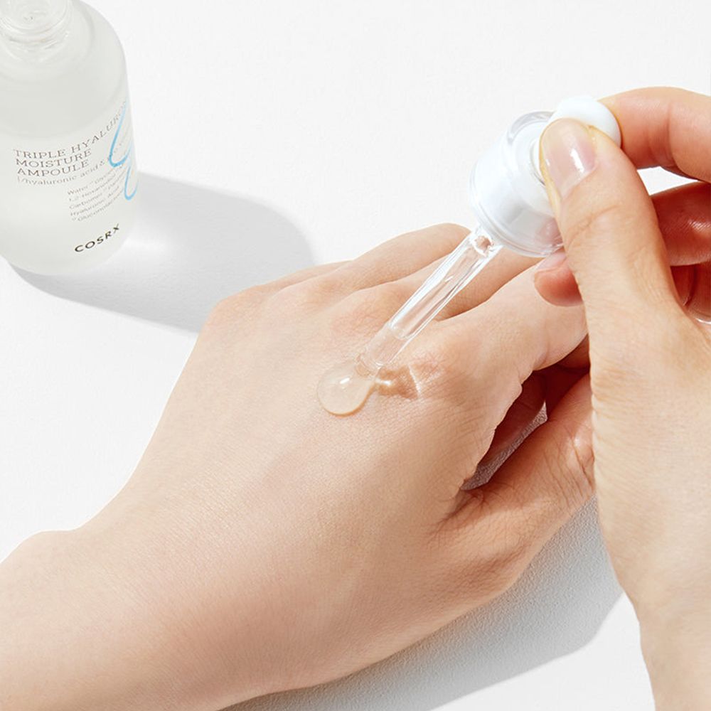 COSRX Triple Hyaluronic Moisture Ampoule wird auf eine Hand aufgetragen.
