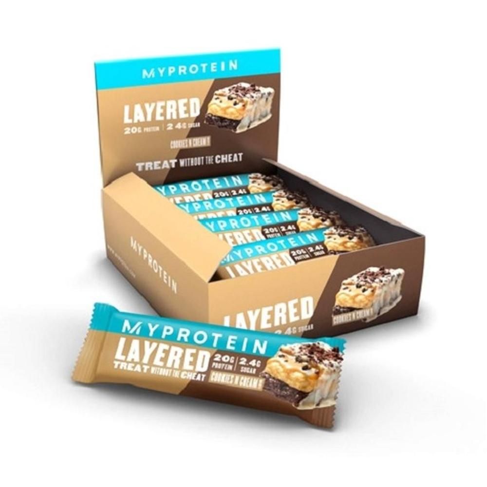 Schachtel mit Myprotein Layered Bars. Einzelne Riegel und geöffnete Schachtel mit Riegeln. Blaue und braune Verpackung.