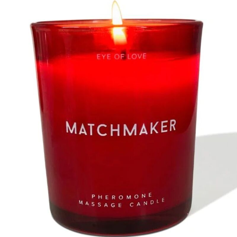Rote Kerze im Glas. Aufschrift: MATCHMAKER, EYE OF LOVE, Pheromone Massage Candle. Brennende Flamme.