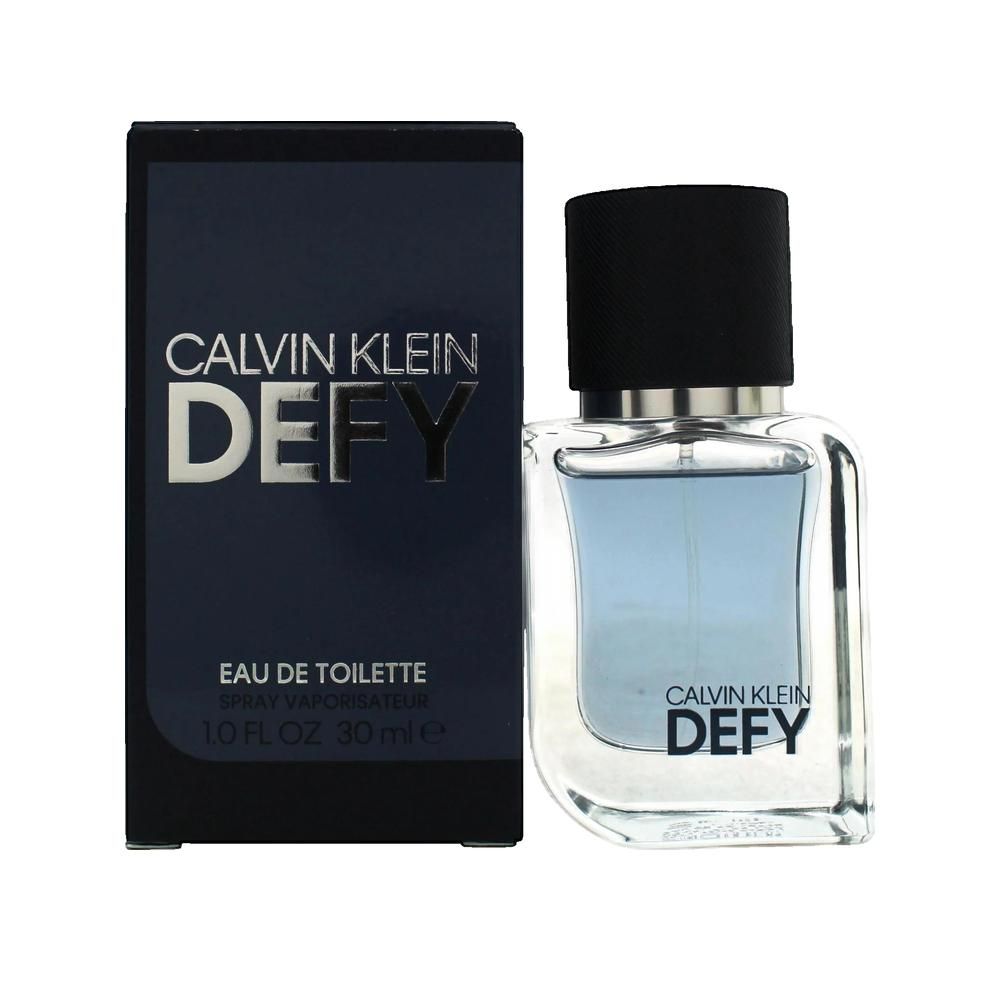 Eau de Toilette Calvin Klein Defy. Flakon mit schwarzem Deckel und blauer Flüssigkeit. Schwarze Verpackung mit Logo.