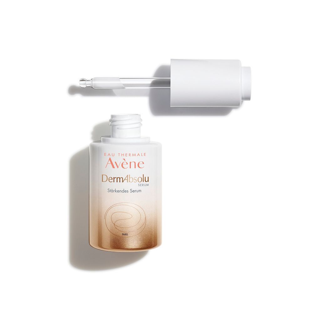 Serumflasche mit Pipette. Aufschrift: Avène DermAbsolu Stärkendes Serum. Flasche und Pipette auf weißem Hintergrund.