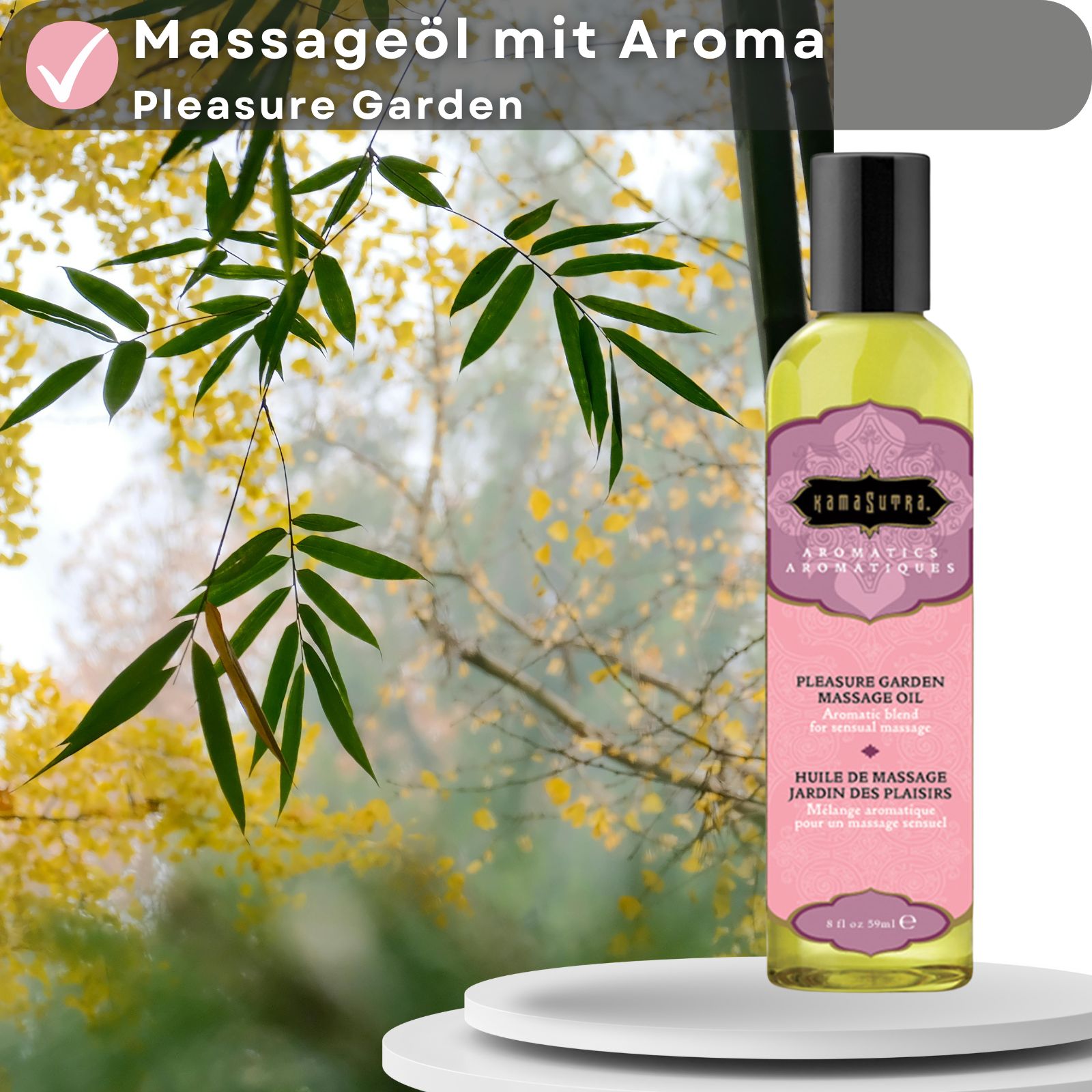 Kamasutra Massageöl mit Aroma Pleasure Garden. Flasche auf weißer Oberfläche, Hintergrund mit Blättern und Bambus.