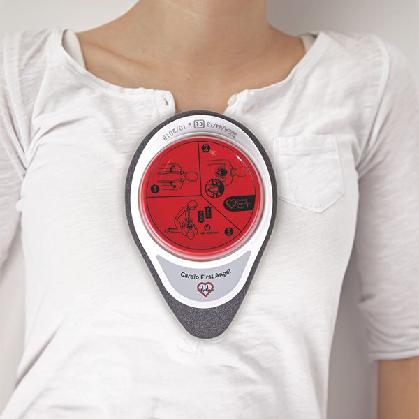 Cardio First Angel auf Brust. Roter Knopf mit Anweisungen, weißer Rahmen, grauer Schaumstoff. Text: Cardio First Angel.