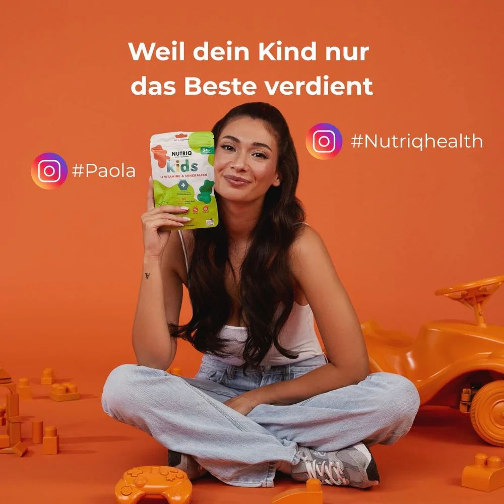 Frau sitzt mit Spielzeug. Hält NUTRIQ Kids Multivitamin & Omega-3. Instagram-Namen: #Paola, #Nutriqhealth.