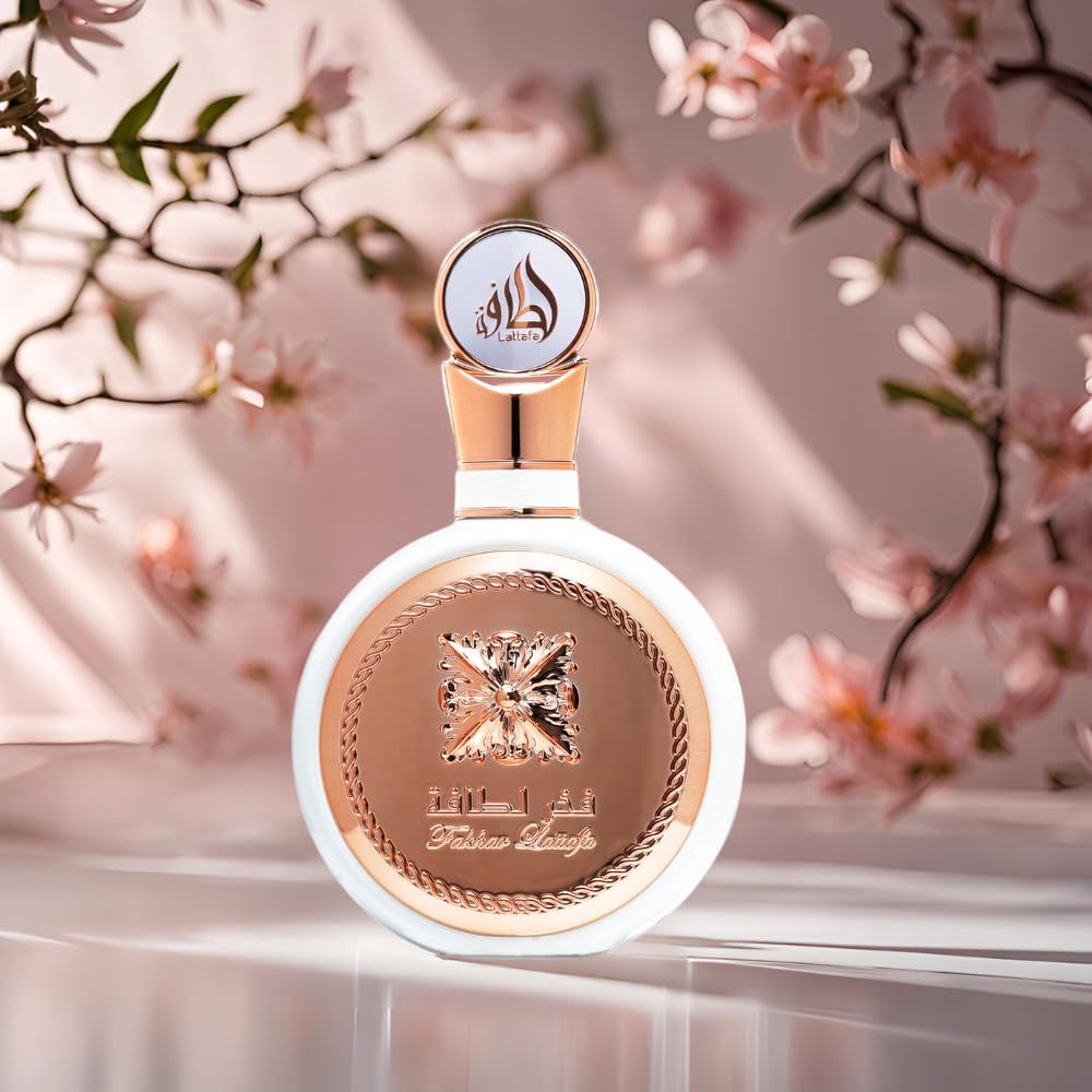 Runde, weiße Flasche mit goldfarbenen Akzenten und einem Deckel. Arabische Schriftzeichen und Logo. Hintergrund: rosa Blüten.