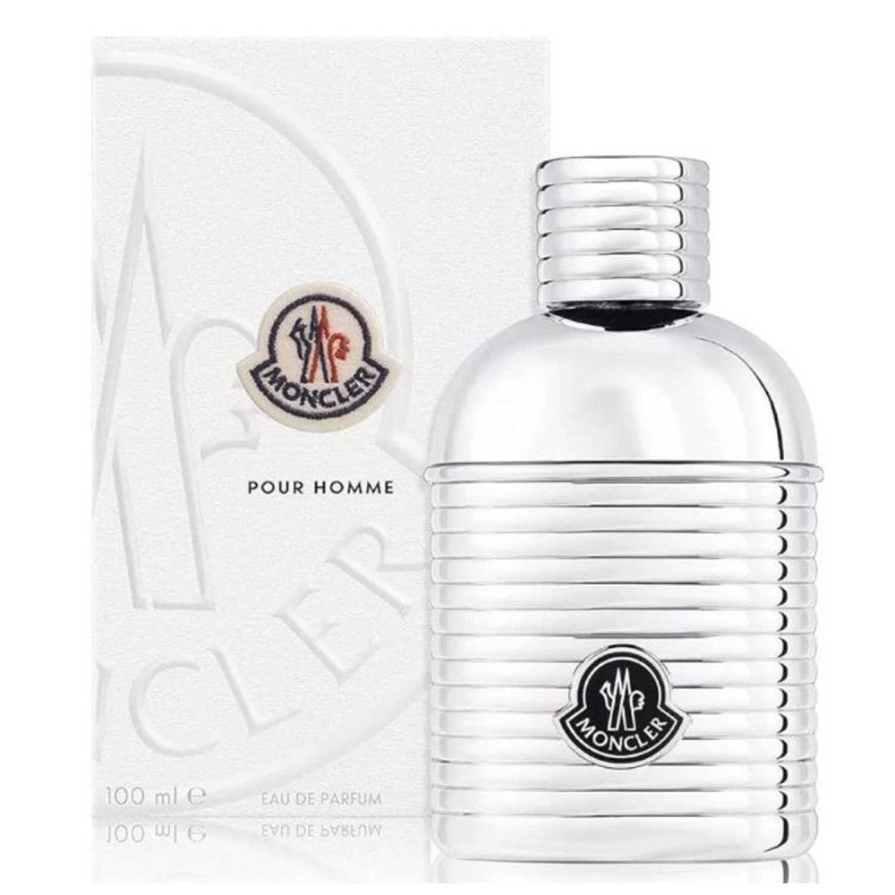 Silberfarbener Flakon mit geriffelter Oberfläche und Logo, neben weißer Verpackung. MONCLER POUR HOMME.