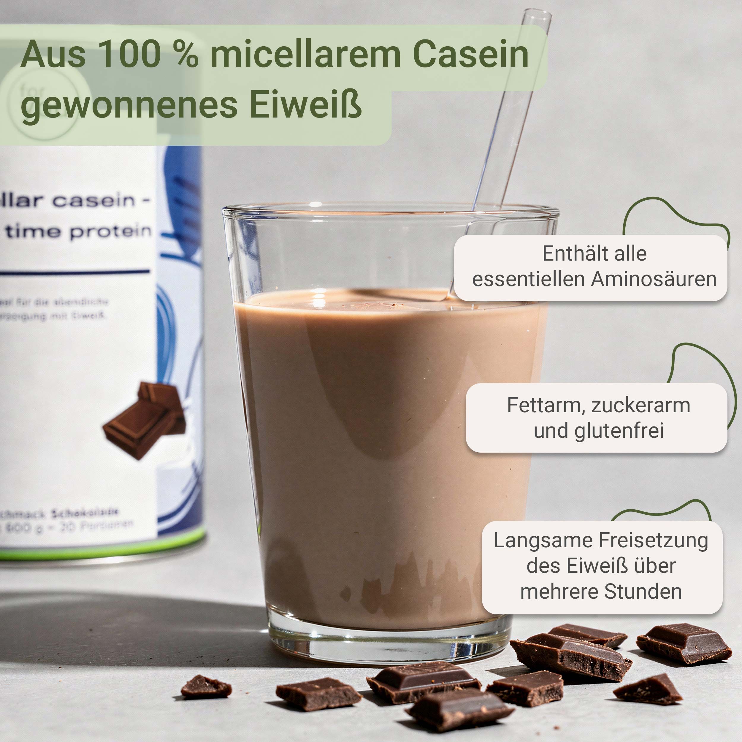 Glas Schokoladen-Proteinshake mit Strohhalm, neben einer Dose und Schokoladenstücken.